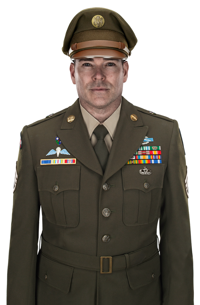 Photo of a US Army Sergeant in Class A uniform featuring a military cap with the US seal, colorful ribbons, and a paratrooper badge against a white background