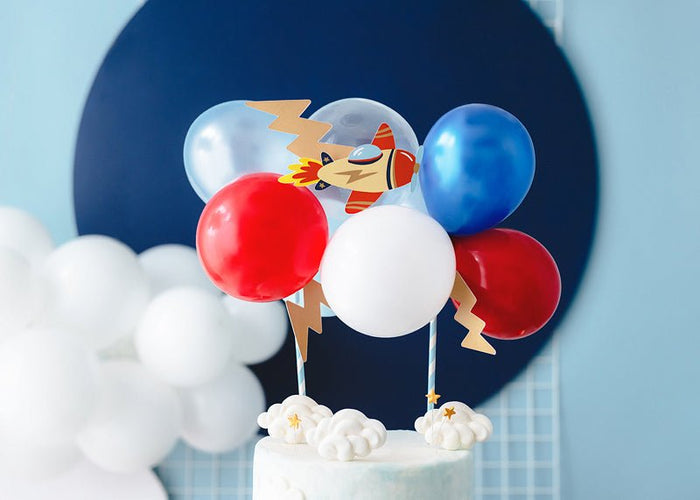 Airplane-themed balloon cake topper with blue, red, and white balloons and cake clouds
