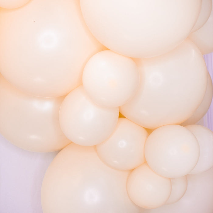 Close-up of blush and cream balloon garland clusters with rounded balloon surfaces