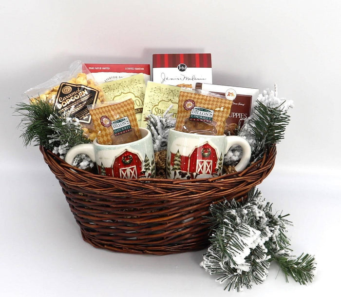 Large wicker Christmas gift basket with two mugs, snack boxes, and frosted greenery