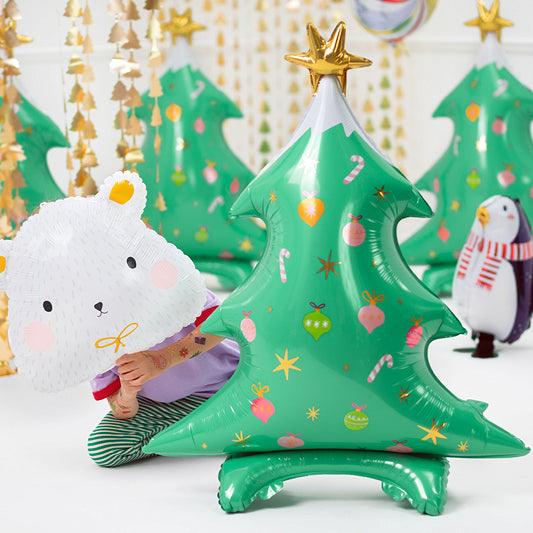 Green Christmas tree standing balloon with gold star topper and decorative holiday print.