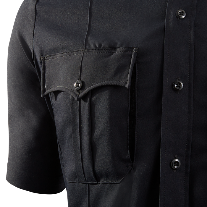 Close-up product shot of a dark navy blue uniform shirt showing a breast pocket with a unique V-shaped flap, three dark buttons, and crisp pleats showcasing the fabric texture
