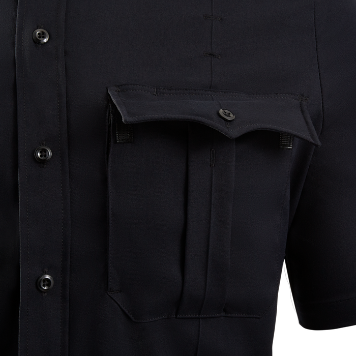 Close-up of a dark navy blue short-sleeved shirt featuring a unique flap pocket, detailed stitching, and dark buttons