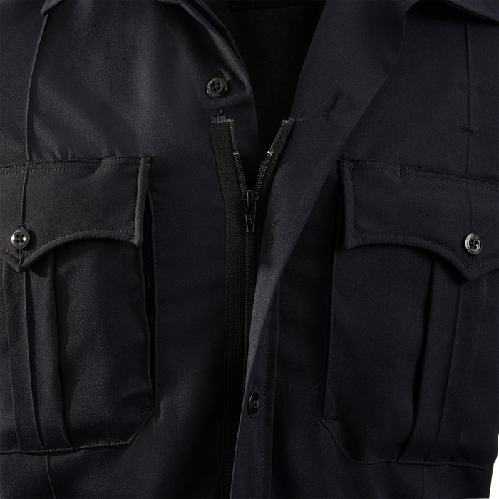 Close-up photograph of a dark navy blue uniform shirt showing a zipper, buttons, and flap pockets