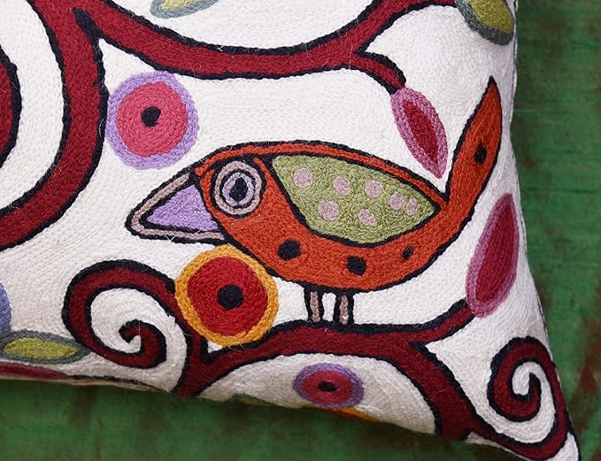 White pillow cover close-up of bird applique and multicolor spiral embroidery