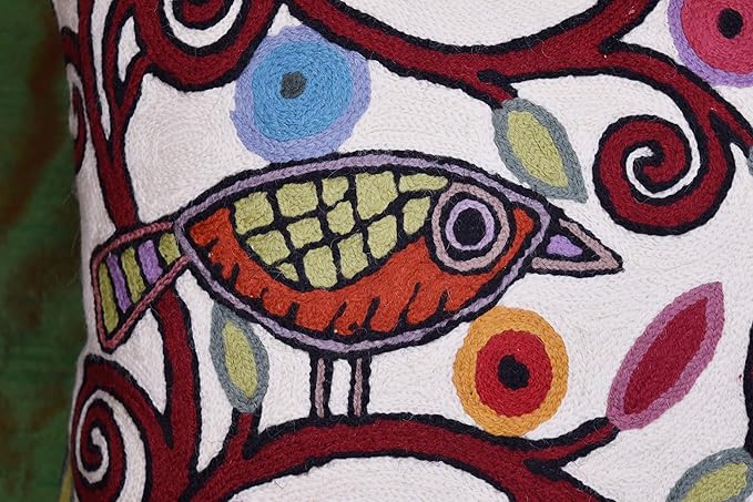 White pillow cover close-up featuring bird motif and bold swirling patterns