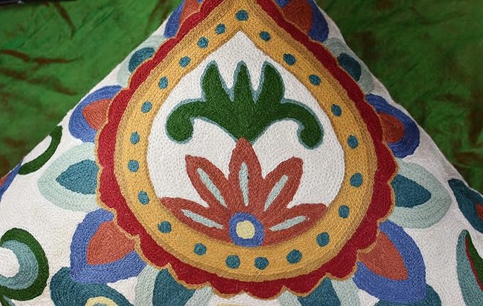 Embroidered paisley-style center medallion on cream pillow cover with red and green thread