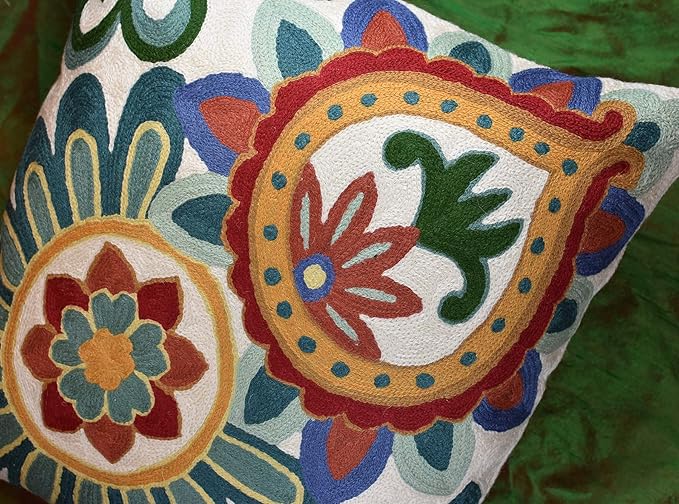 Embroidered floral pillow cover with two circular flower medallions in teal, red, blue, and green