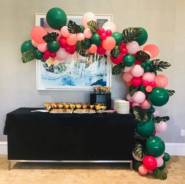 Safari jungle balloon garland with pink/green balloons and leafy accents, corner display