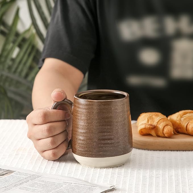 Brown speckled ceramic coffee mug with handle, rounded body, and white base