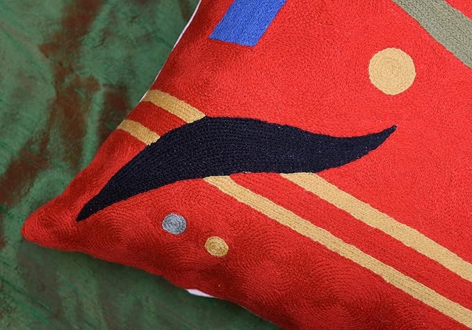 Red abstract pillow cover corner with dark bird silhouette and blue dot