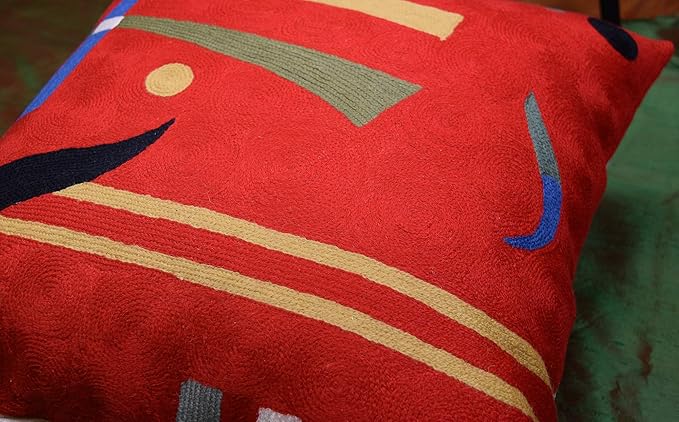 Red abstract pillow cover with dark bird shape, blue accent marks, and stripes