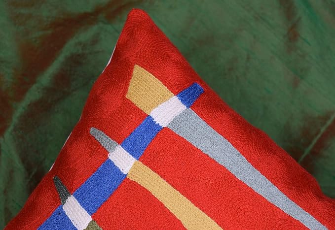 Red abstract pillow cover corner with layered blue, beige, and gray geometric blocks