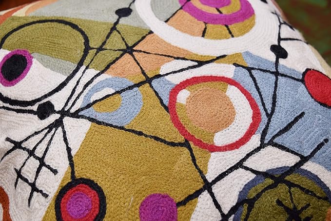 Close-up wool pillow cover detail with red, purple, and orange circles in grid lines.