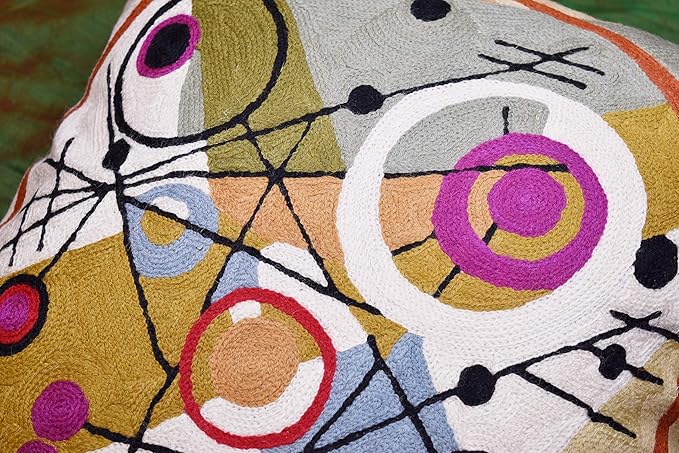 Wool pillow cover close-up with purple and gray circular eyes, dots, and black lines.
