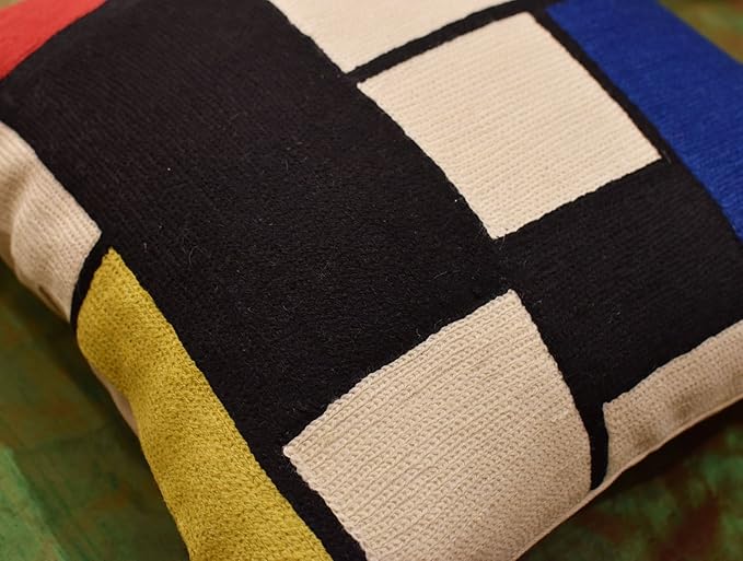 Geometric pillow cover close-up: black blocks with blue, white, red, and yellow accents