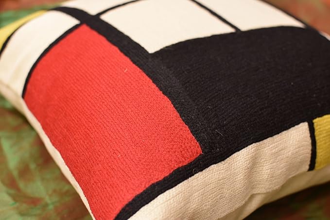 Geometric pillow cover close-up: red and black blocks with white lines on cream
