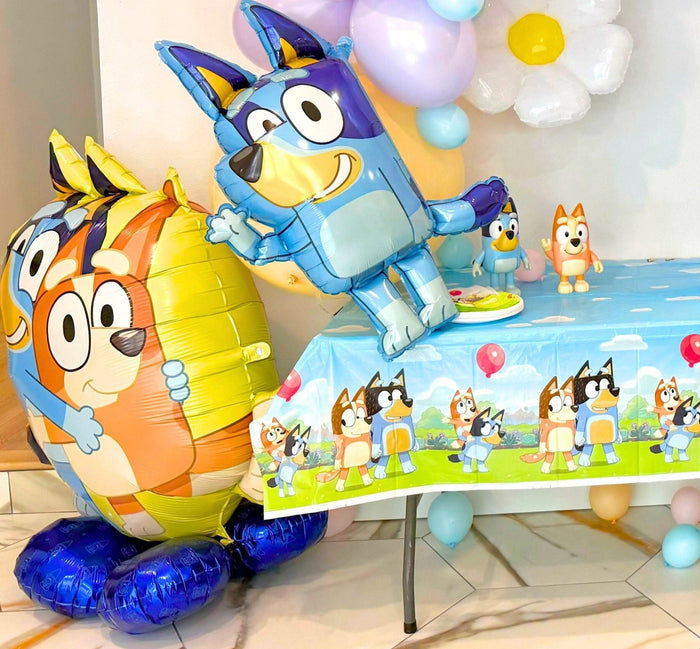 Bluey and Bingo character balloons on a table with small character balloon accents