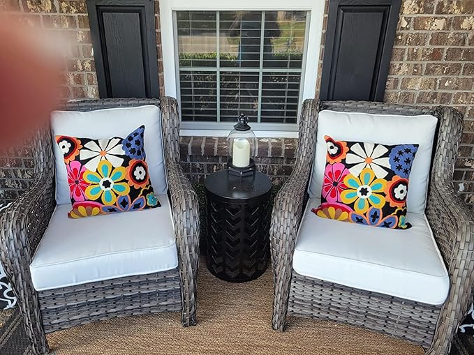 Embroidered floral accent pillow on outdoor chair seat, colorful daisy motif