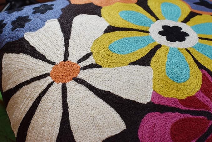 Close-up embroidered flower petals and daisy centers in blue, yellow, and orange