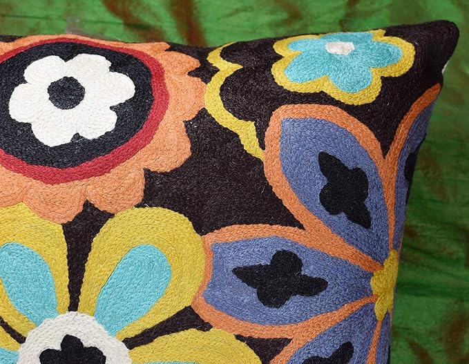 Embroidered floral pillow cover with multicolor flower shapes on dark background