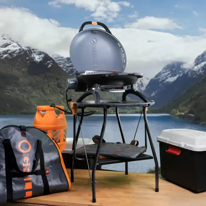 A promotional image of an o-grill stood on the stand with all accessories around it