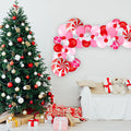 Christmas balloon garland with red, pink, white and candy-cane swirl accents