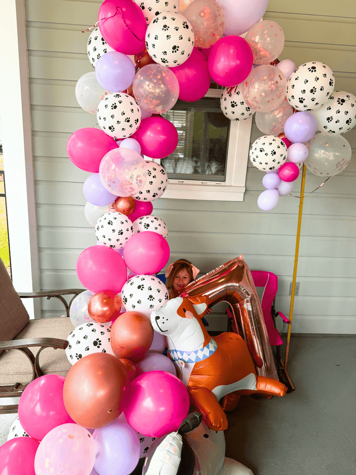 Pink and white balloon garland with light purple and dog-print balloons cluster