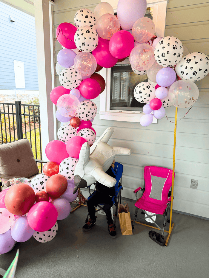 Balloon garland cluster with pink, white, and light purple balloons and dog-print spheres
