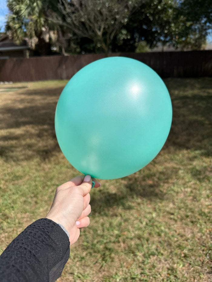 Sea foam latex balloon held in a hand
