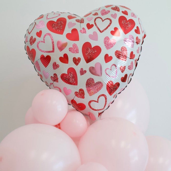 Heart balloon bouquet featuring patterned red and pink foil heart with light pink latex balloons
