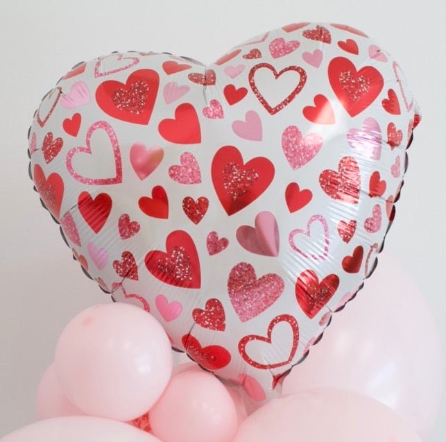 Heart balloon bouquet with glitter-style hearts on white foil heart and clustered pink latex balloons
