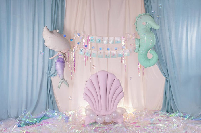Upright pink seashell balloon centered in pastel balloon backdrop