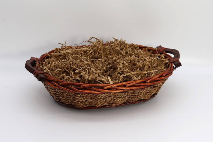 Wicker gift basket filled with shredded straw filler and ribbon trim