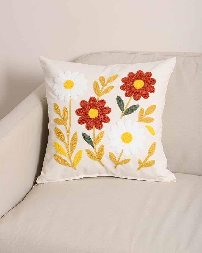 White embroidered pillow cover with yellow daisies and red blooms on front view