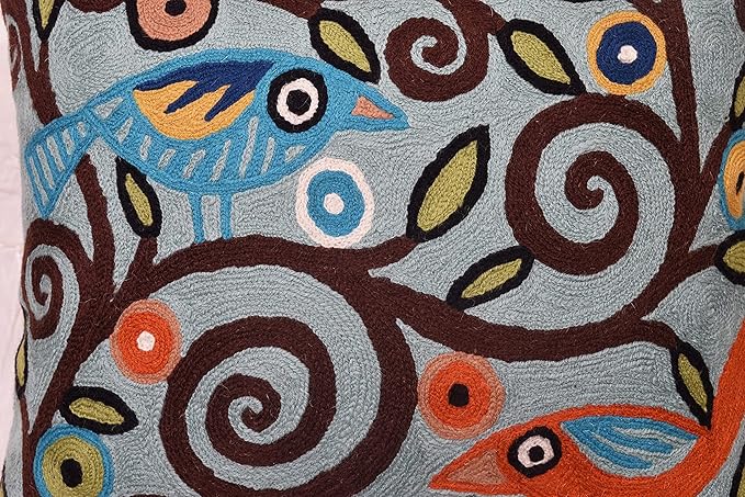Embroidered teal birds and floral swirls on textured pillow cover
