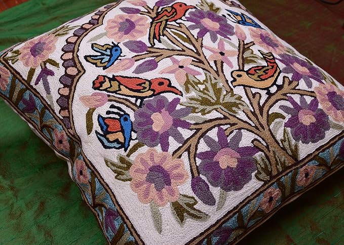 Needlepoint pillow cover with colorful birds perched among purple blossoms