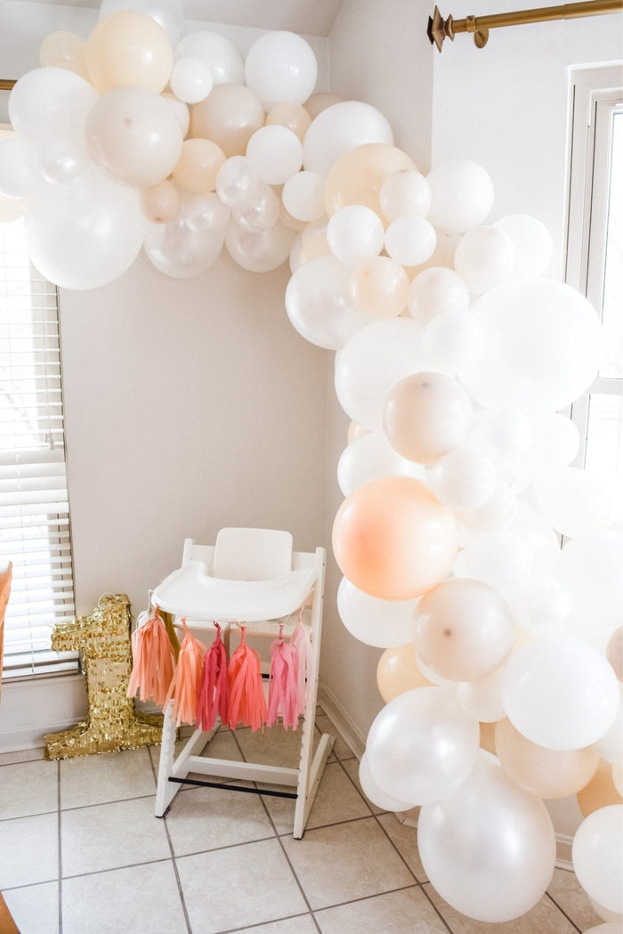 White balloon garland with sweeping columns of round white balloons indoors