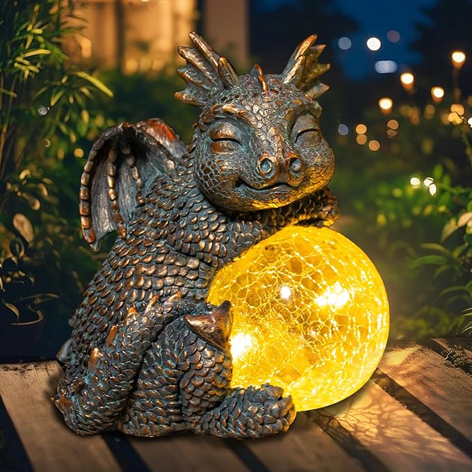 Sleeping blue dragon figurine holding a glowing crackled globe solar light for garden