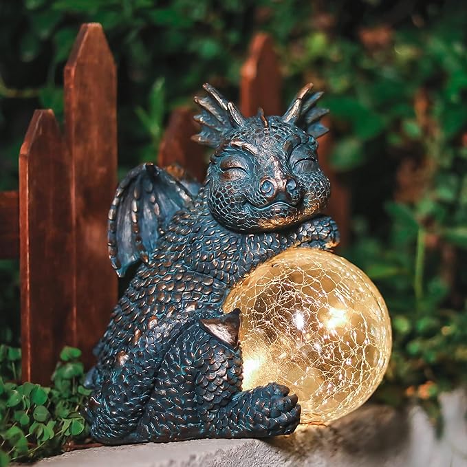 Blue dragon garden ornament seated with a warm golden crackled globe solar light