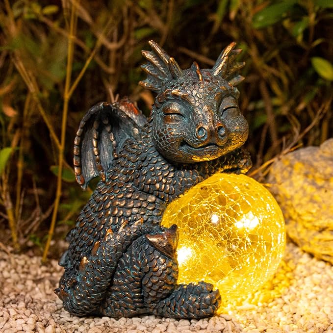 Blue dragon figurine resting with a bright yellow crackled glass globe solar light