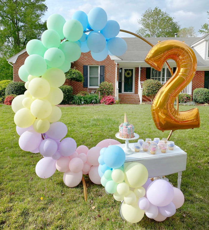 Gold foil balloon number 2 with pastel balloon clusters and yard display